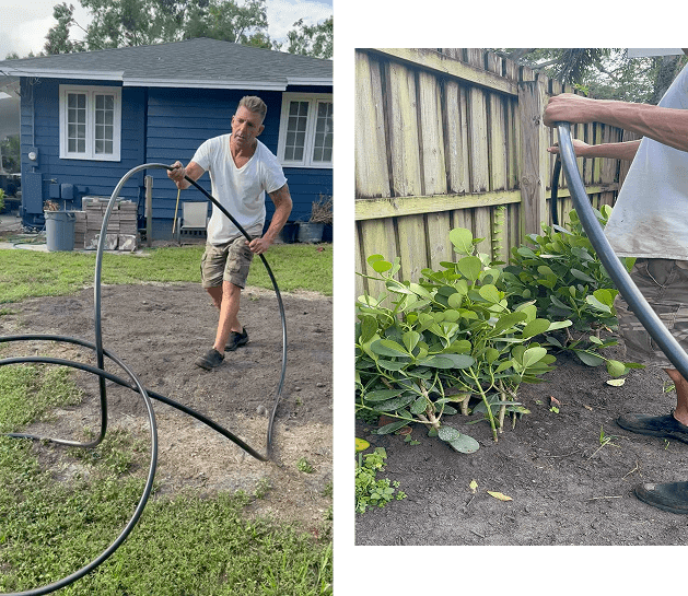 Person watering plants in a garden using a hose.