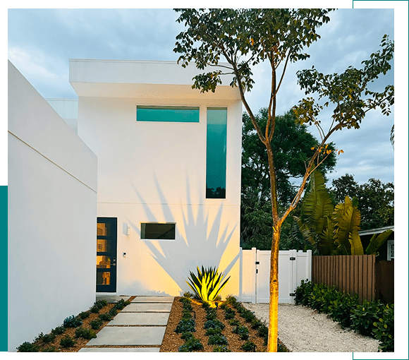 Modern white house with tall windows and a minimalist garden.