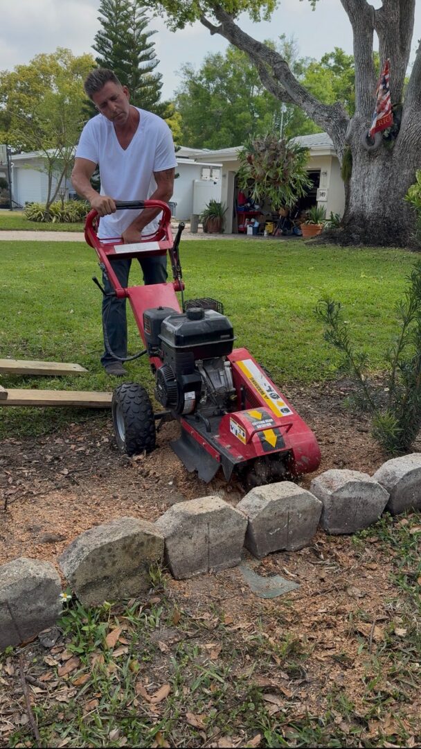 Person operating lawn edger near stone border